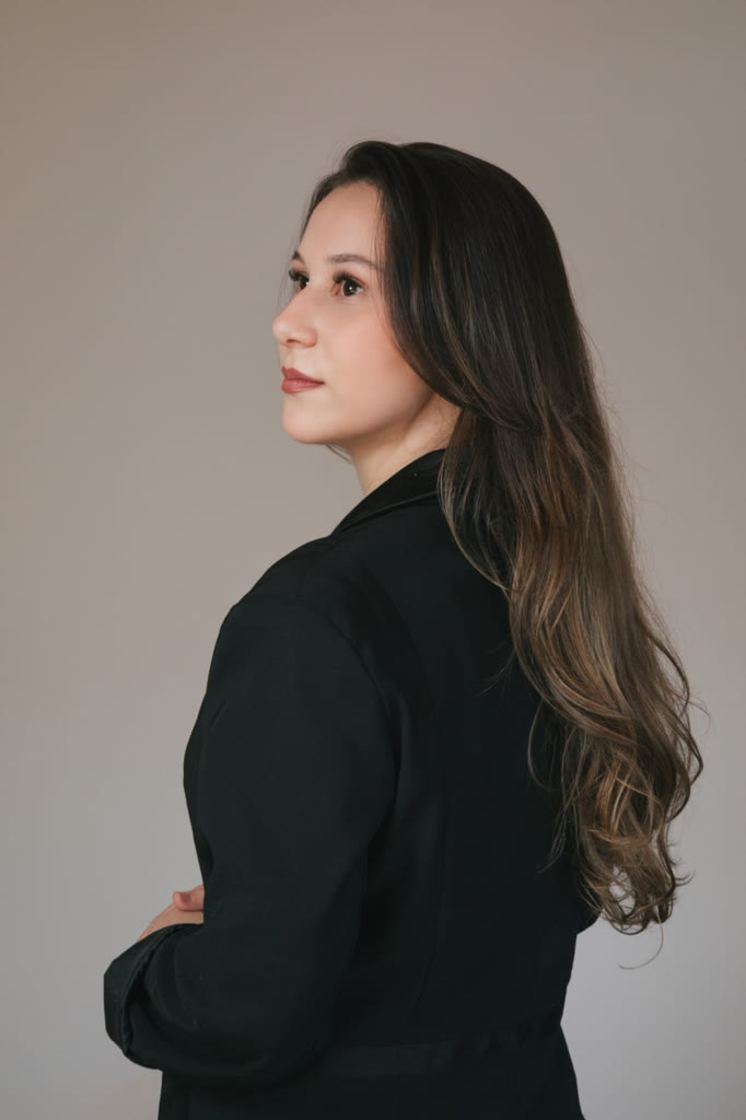 Retrato de perfil da Dra. Júlia de blazer preto